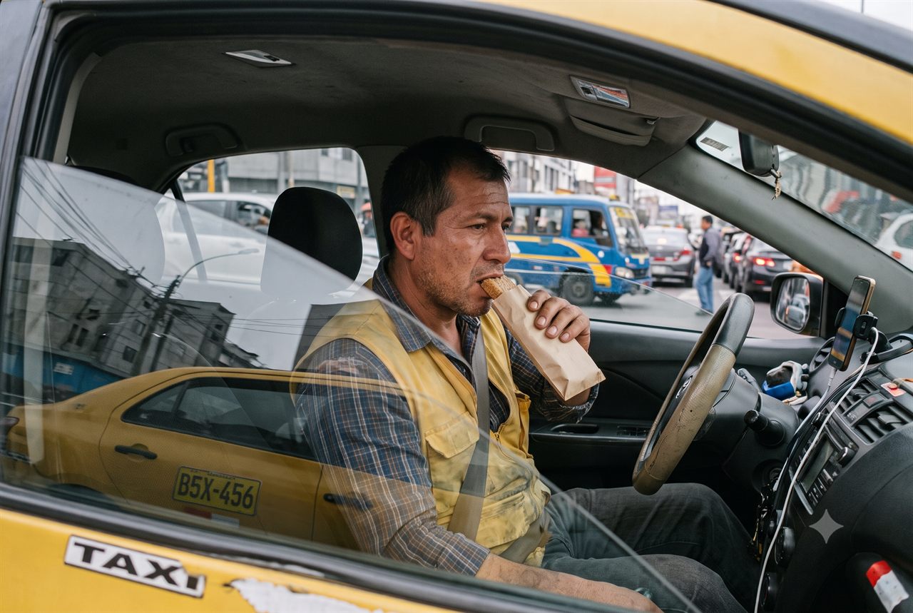 Taxista come algo rápido al volante, detenido en el tráfico de Lima